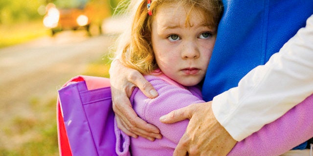 Schoolgirl Hugging Her Mom — Image by © Jim Craigmyle/Corbis