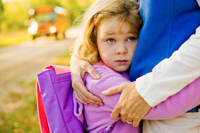 Schoolgirl Hugging Her Mom — Image by © Jim Craigmyle/Corbis